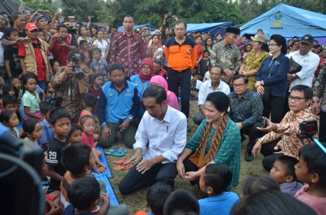 Presiden Jokowi dan Ibu Negara Iriana menghibur para pengungsi Erupsi Gunung Agung di Lapangan Desa Ulakan, Kabupaten Karangasem, Selasa (26/9) sore. (Foto: Humas/Jay