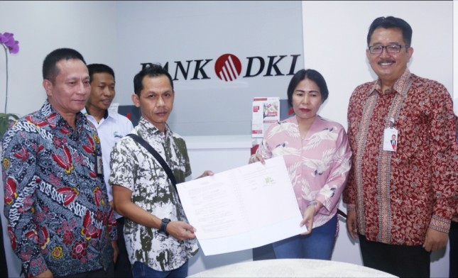 Direktur Bisnis Bank DKI, Antonius Widodo Mulyono (Paling Kanan) didampingi Pemimpin Bank DKI Cabang Matraman, Athos Yun Indra (paling kiri) usai menyaksikan nasabah menandatangani perjanjian kredit pada peresmian Kantor Layanan Bank DKI di Pasar Pra