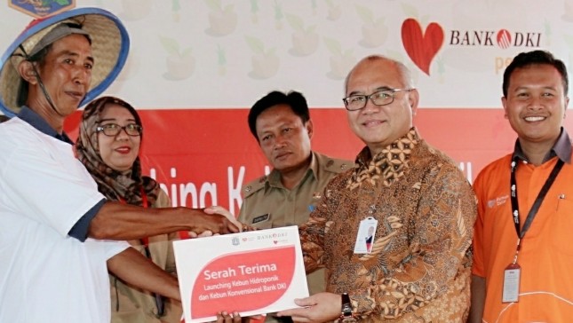 Direktur Kepatuhan Bank DKI, Budi Mulyo Utomo, bersama Direktur Rumah Zakat, Asep Nurdin (paling kanan), memberikan simbolis bantuan penyediaan fasilitas kebun Hidroponik kepada warga di Rusunawa Jatinegara Kaum di Jakarta, (12/12).