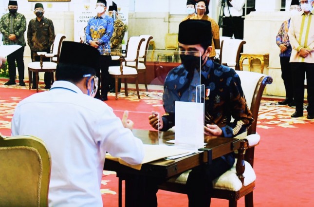 President Jokowi hands over zakat or alms to the BAZNAS at the State Palace in Jakarta