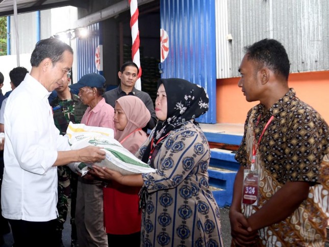President Jokowi distributes food assistance to beneficiaries, at the State Logistics Agency’s (Bulog) warehouse in East Rawang, Padang, West Sumatra province, on Wednesday (10/25). (Photo by: BPMI of Presidential Secretariat/Rusman)