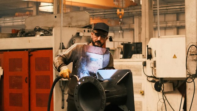 A technician working on industrial equipment inside a factory