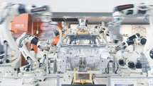 Industrial robotic arms working on a car body assembly line