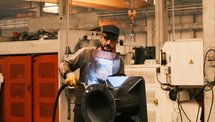 A technician working on industrial equipment inside a factory